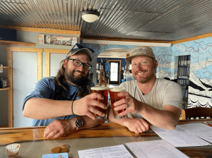 Two people cheers-ing at Browns Brewpub